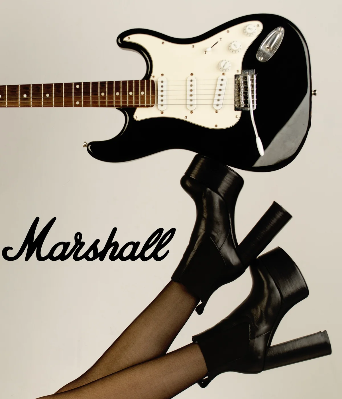 Botas de plataforma y guitarra eléctrica sobre fondo con el logo de Marshall