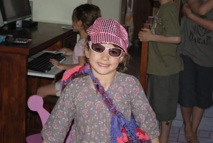 Consuelo de niña con gorra rosa con brillos y anteojos de sol