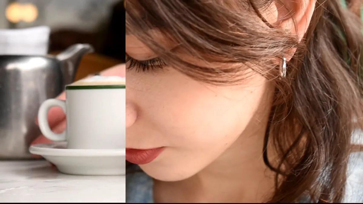 Fotograma del fashion film: primer plano de una joven de perfil junto a una taza de café
